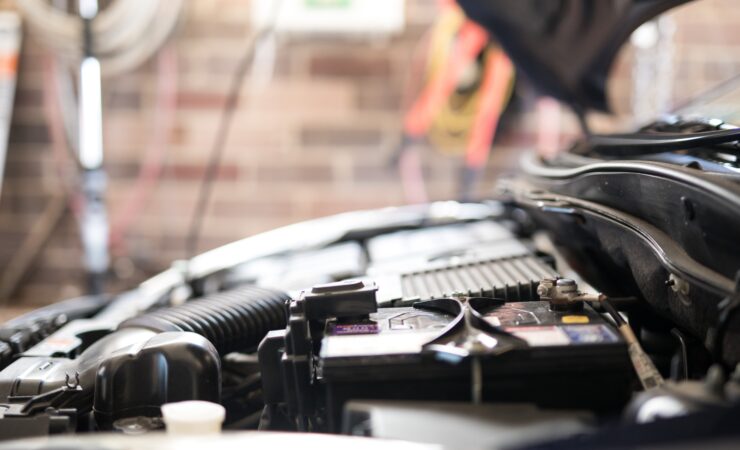 A close-up view of a clean car engine bay, showcasing various components such as the air intake, battery, and fuse box.