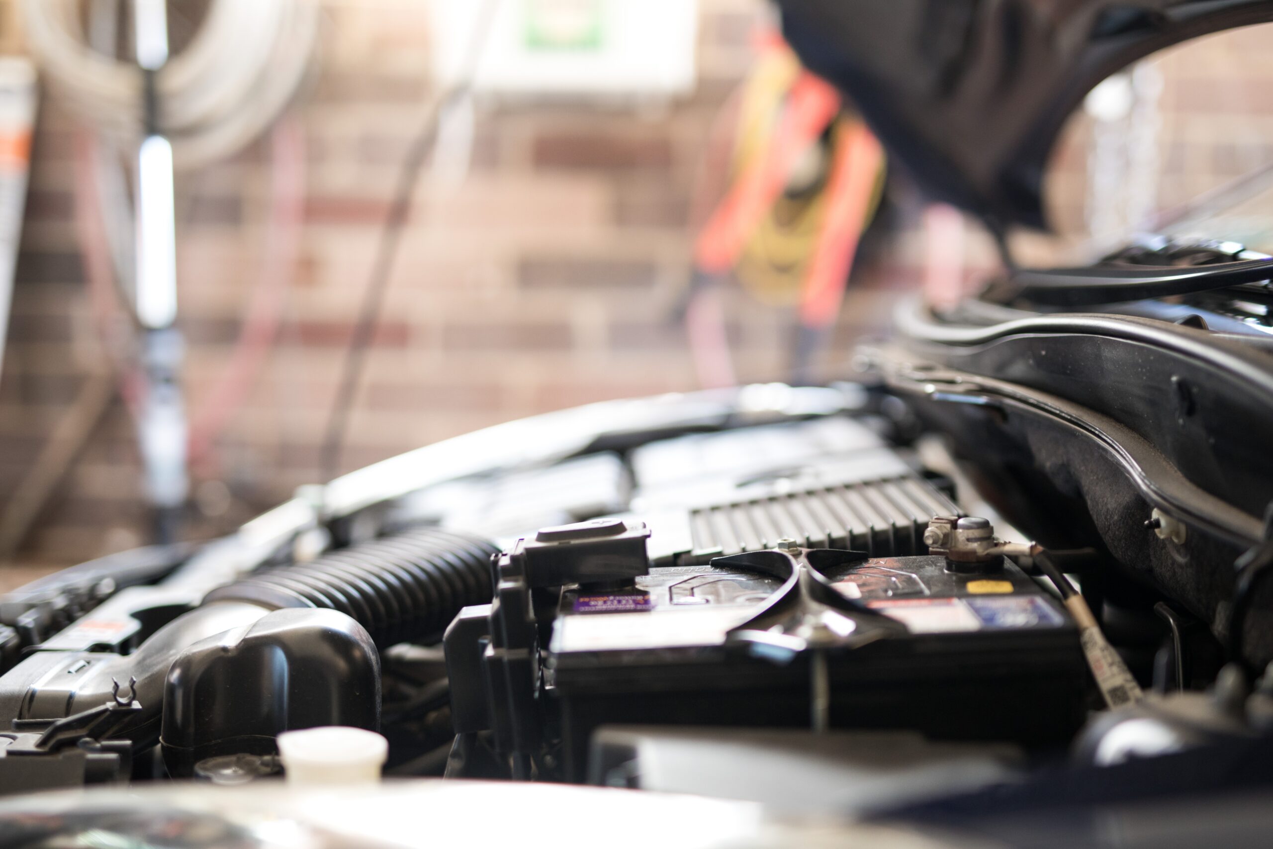 A close-up view of a clean car engine bay, showcasing various components such as the air intake, battery, and fuse box.