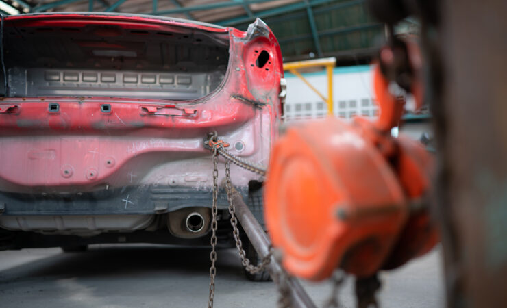 A severely damaged car, its body crumpled and distorted from a high-speed collision.