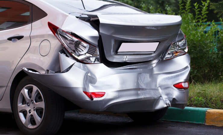 A car with a large dent in its side panel.