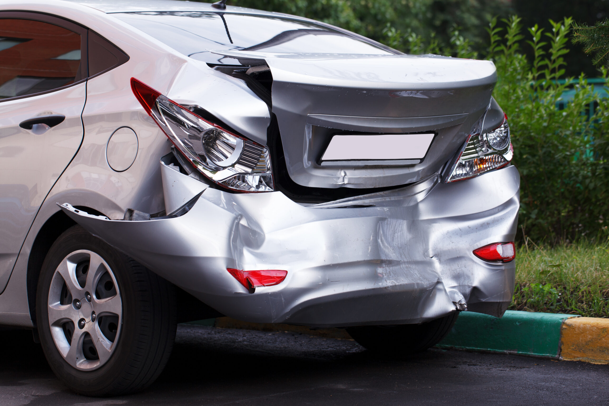 A car with a large dent in its side panel.